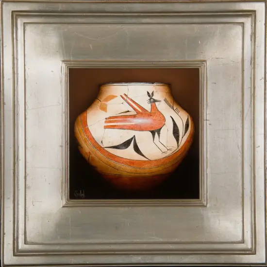 Ceramic vase with a red bird design in a recessed display frame. (Decorative pottery shown in a silver frame)