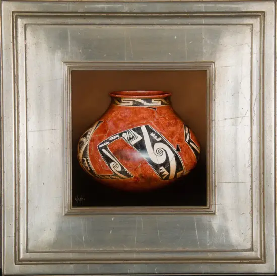 Red ceramic vase with bold black-and-white geometric patterns, centered in a silver gallery frame.