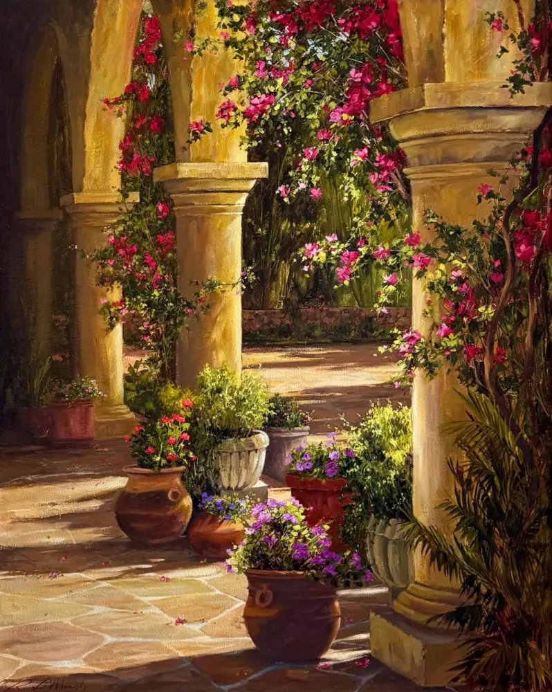 Sunlit stone courtyard with columns and pink flowering vines cascading over them.