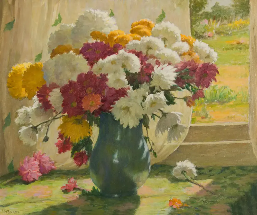 Vase of mixed chrysanthemums in a blue-green vase on a sunlit table by a window, with yellow, red, white blossoms and a garden view outside.