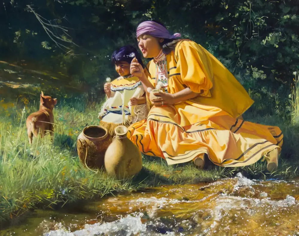Two people in colorful dresses sit by a stream, with round clay pots nearby and a small brown dog on the grass behind them.