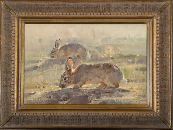 Painting of two rabbits in a grassy field, viewed in a decorative bronze frame