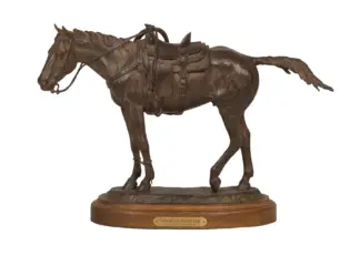 Bronze statue of a horse with saddle and reins on a wooden base, titled 'Cowboy's Partner'.