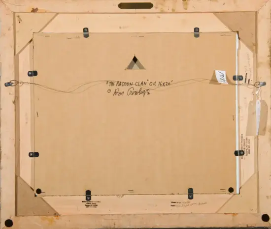 Back of a framed painting: brown cardboard backing, mounting hardware, and a wire hanging system with handwritten title 'THE RACCOON CLAN' OIL 16x20 on the back.
