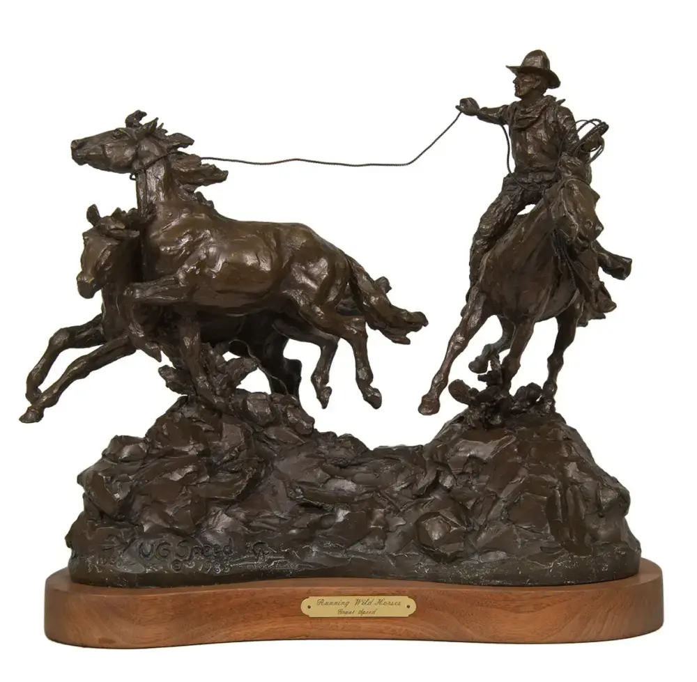 Bronze sculpture of a cowboy on a horse roping two galloping wild horses on a rocky base, mounted on a wooden plaque.