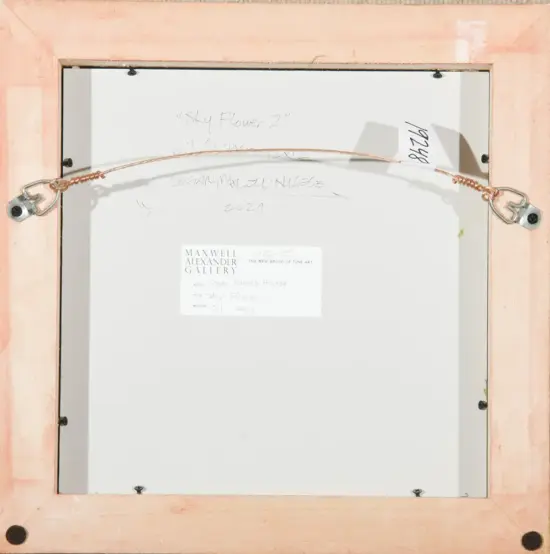 Back of a framed artwork showing a copper hanging wire and gallery label, with handwritten notes on the white backing.