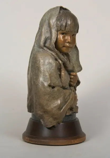 Bronze-toned sculpture bust of a young girl wearing a hooded cloak on a dark pedestal base