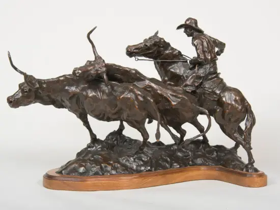 Bronze sculpture showing a cowboy on a horse roping two bucking bulls, mounted on a wooden base.