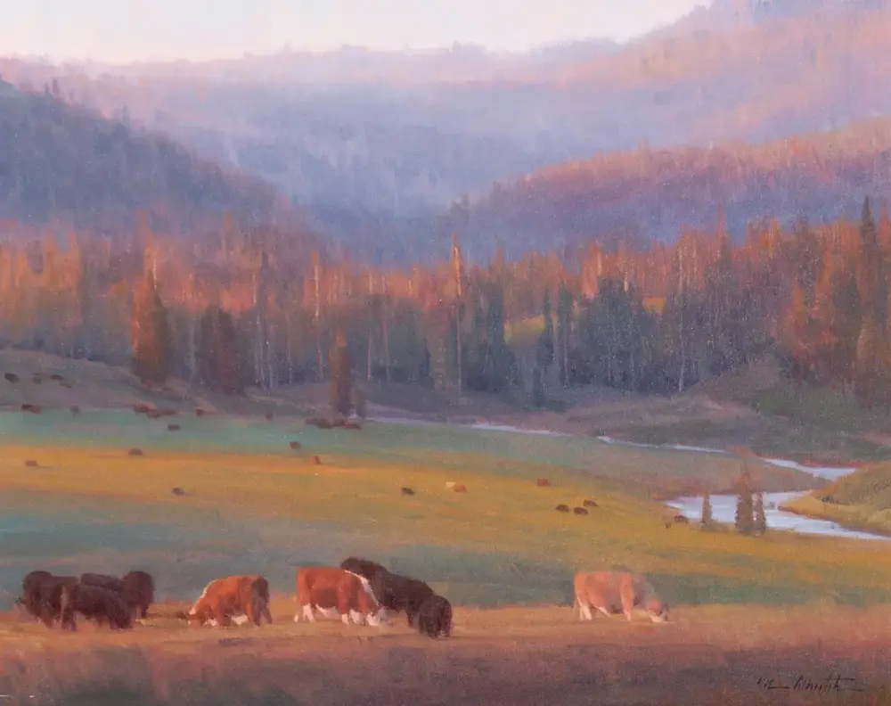 Pastel landscape of a meadow with grazing cows in the foreground, a forested hillside and soft autumn colors in the distance.