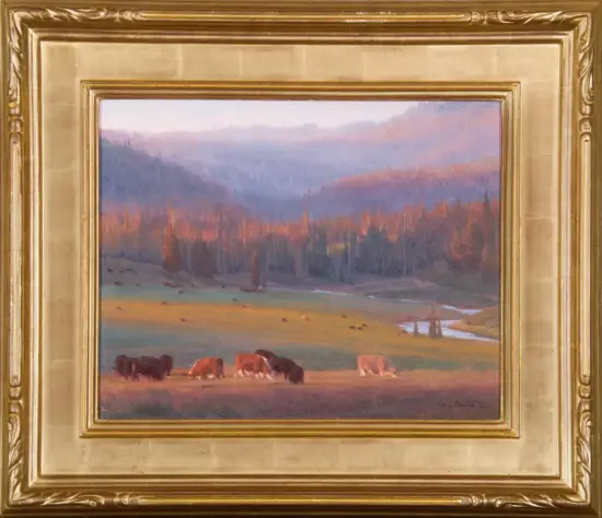 Pastoral landscape painting of cows grazing in a sunlit meadow with trees and distant mountains, in a gilded frame.