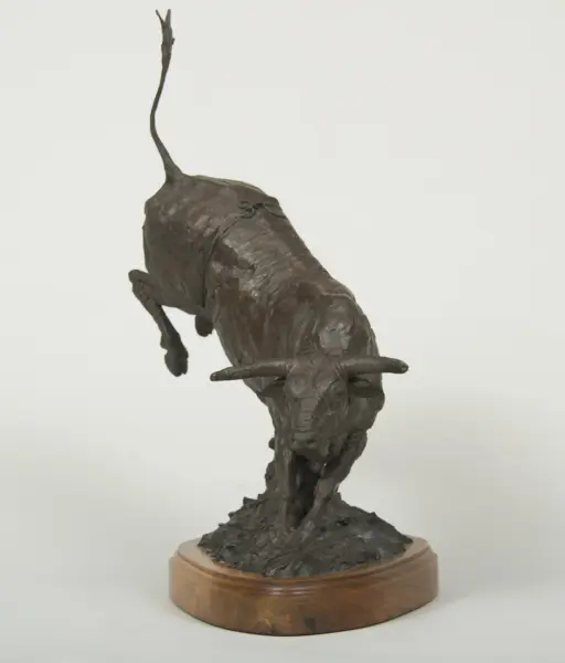 Bronze sculpture of a stylized figure with an elongated neck and raised arm on a round wooden pedestal.