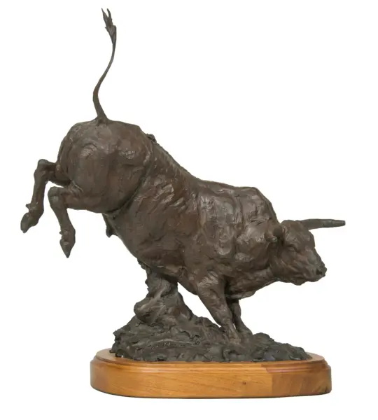 Bronze sculpture of a standing dog on a round wooden base with a textured surface.
