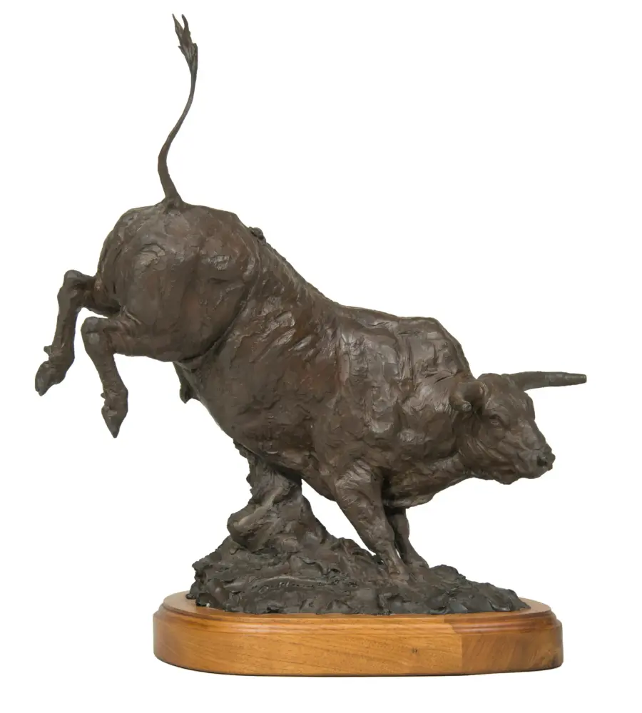Bronze sculpture of a standing dog on a round wooden base with a textured surface.