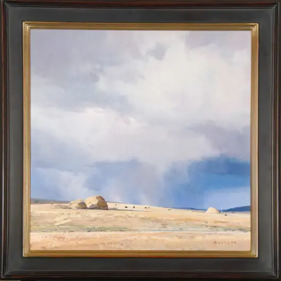 Framed landscape painting of a desert scene with sandy plains, distant rock formations, and a cloudy blue sky.