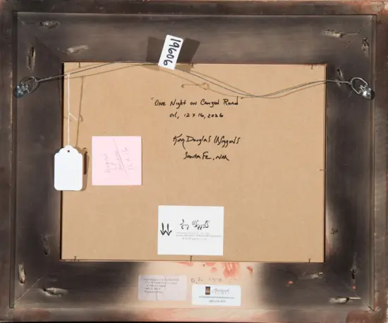Back of a framed artwork with hanging wire, tags, and a handwritten label on the backing.