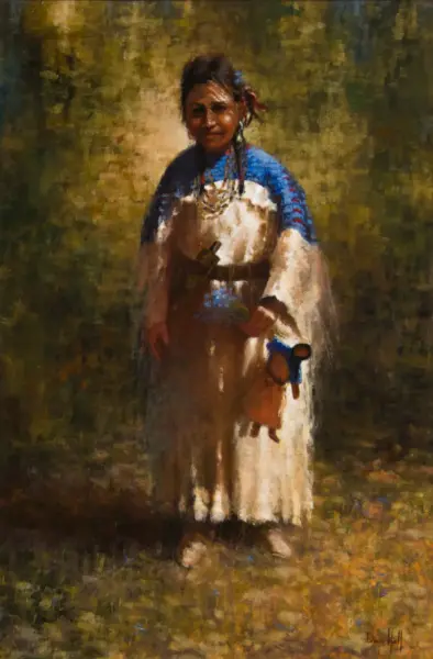 Young woman in a white dress with a blue shawl and traditional jewelry stands in a grassy field, holding a small bouquet.