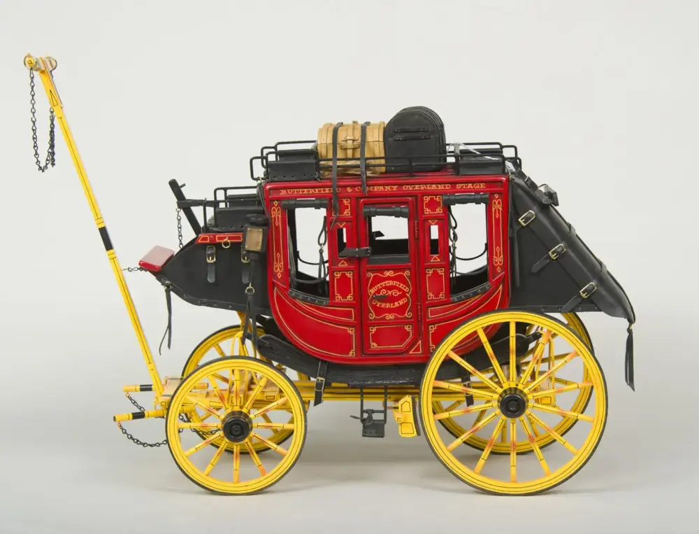 Vintage red and gold stagecoach with bright yellow wheels and black trim, a decorative antique carriage common in the 19th century.