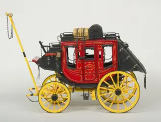Vintage red and gold stagecoach with bright yellow wheels and black trim, a decorative antique carriage common in the 19th century.