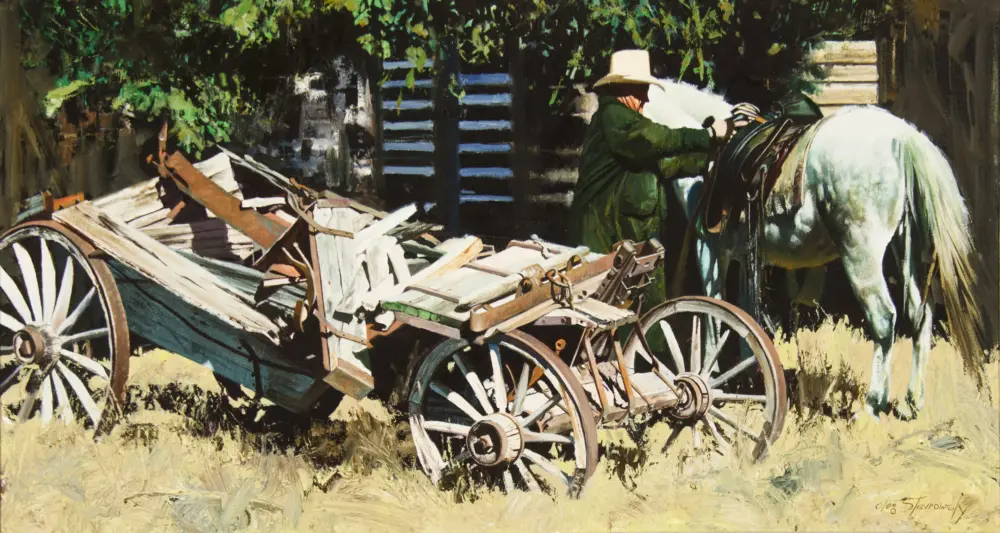 Old man in a wide-brim hat standing beside a white horse hitched to a wooden cart loaded with rough-cut planks and logs in a rural scene.