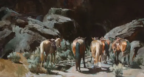 A row of saddled horses standing in a dim, rocky cavern.