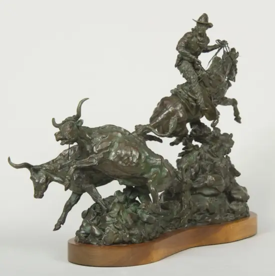 Bronze sculpture showing a group of horsemen charging, mounted on a wooden base/pedestal.