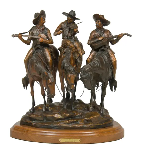 Bronze sculpture of three cowboys on horseback playing string instruments, mounted on a wooden base.
