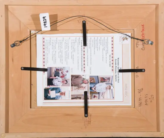 Back of a framed artwork showing hanging wire, braces, and a printed sheet inside the frame