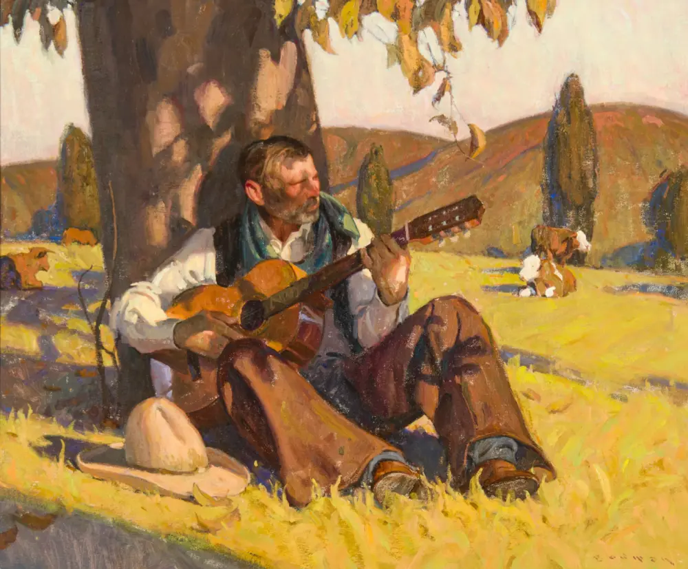 Man with a beard playing a guitar outdoors in a sunny field amid warm autumn colors; hills in the background.