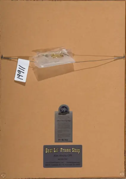 Back of a wooden picture frame with a hanging wire across, a small bag of hardware, a white tag labeled 1911, and business cards attached to the frame.