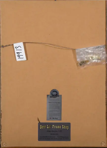Back of a framed picture: a metal hanging wire with a white tag reading 1913, taped hardware in a small plastic bag, and a 'Best Lil' Frame Shop' business label at bottom.