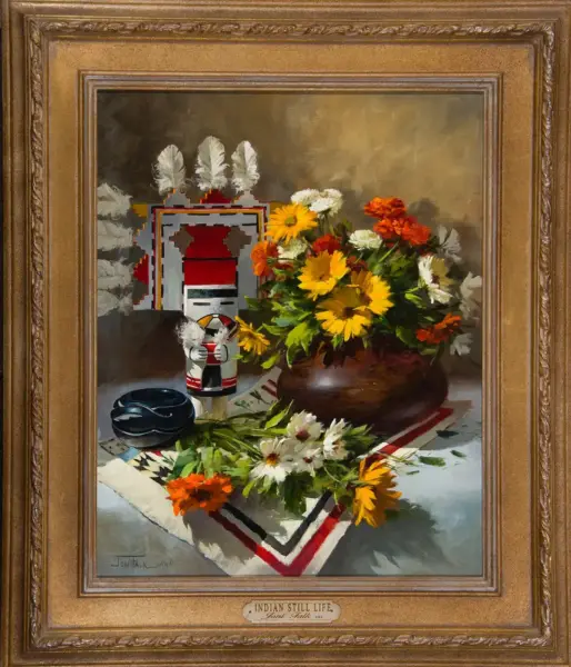 Framed still-life painting showing a brown vase with bright sunflowers, white daisies, and orange flowers on a patterned cloth, with a small carved figure and a black bowl nearby.