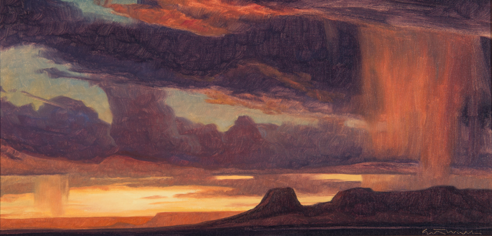 Sunset over a desert with dark storm clouds and silhouetted mesas along the horizon, warm orange glow spreading across the scene.