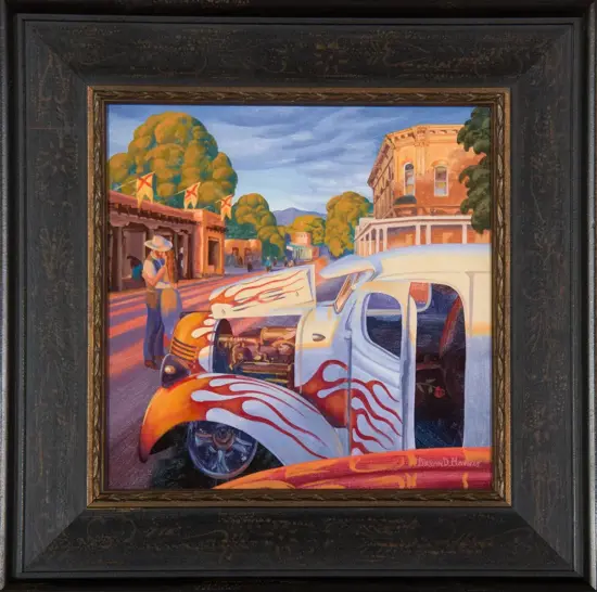 Flaming vintage hot-rod on a sunlit street, with a man beside a shop and brick buildings in the background.