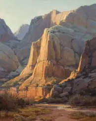 Sunlit red and orange rock cliffs rise over a dry desert valley with sparse vegetation.