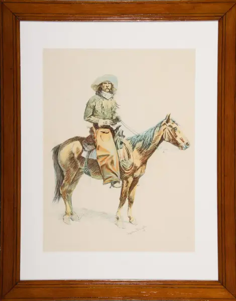 Drawing of a cowboy in a wide-brim hat riding a horse, framed in a wooden picture frame