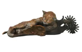Bronze sculpture of a reclining, textured animal with a radial, spoked form at its rear end.