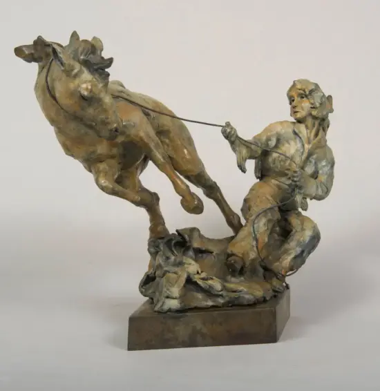 Bronze sculpture of a man guiding a rearing horse, rope in hand, mounted on a rocky pedestal