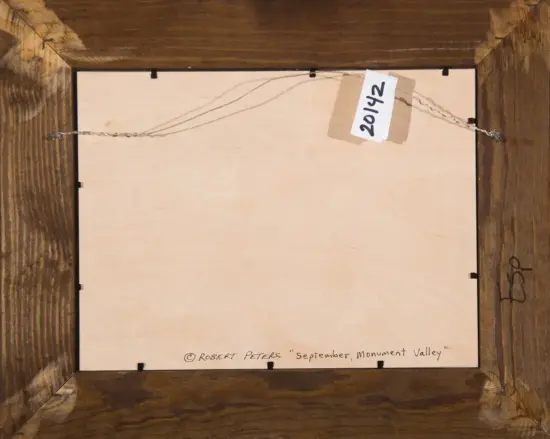 Back of a framed painting: visible hanging wire, wooden frame, and a small white tag with '2014' attached. Signature reads 'Robert Peters, September, Monument Valley' along the bottom edge.