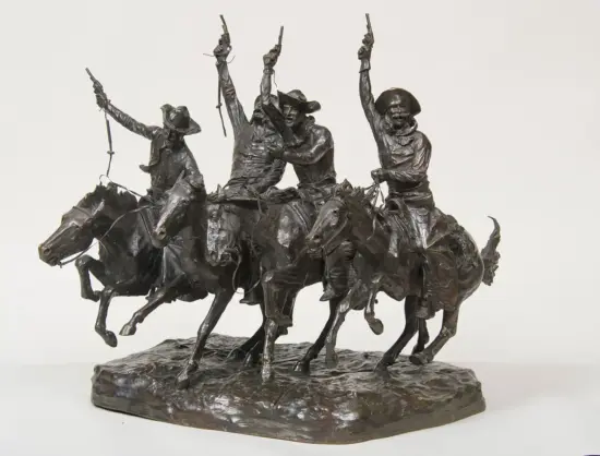 Bronze sculpture of four cowboys on galloping horses, each with a raised pistol in a dynamic frontier scene